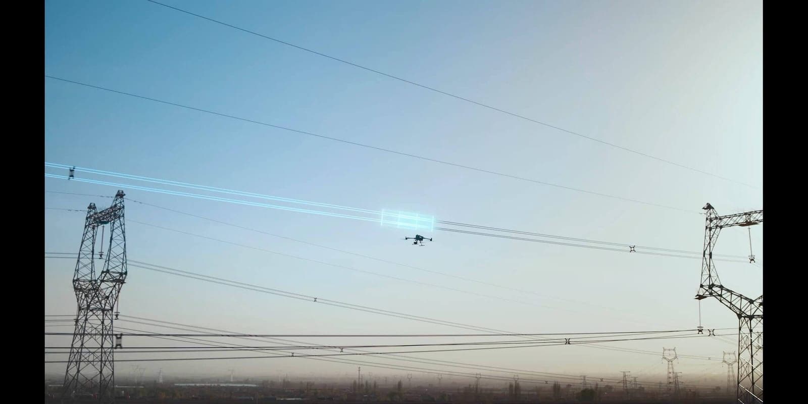Dron u letu uz dalekovod, provodnici se pružaju kroz kadar do stubova u daljini